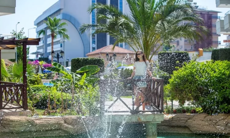 A woman is staying on the bridge of the ornamental pool