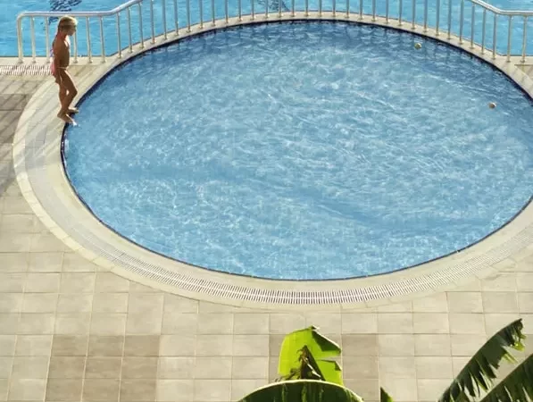 a child is staying near the kid's pool
