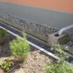 Illustrative house foundation with a gravel drainage channel and rainwater downpipe for Turkey drainage checks