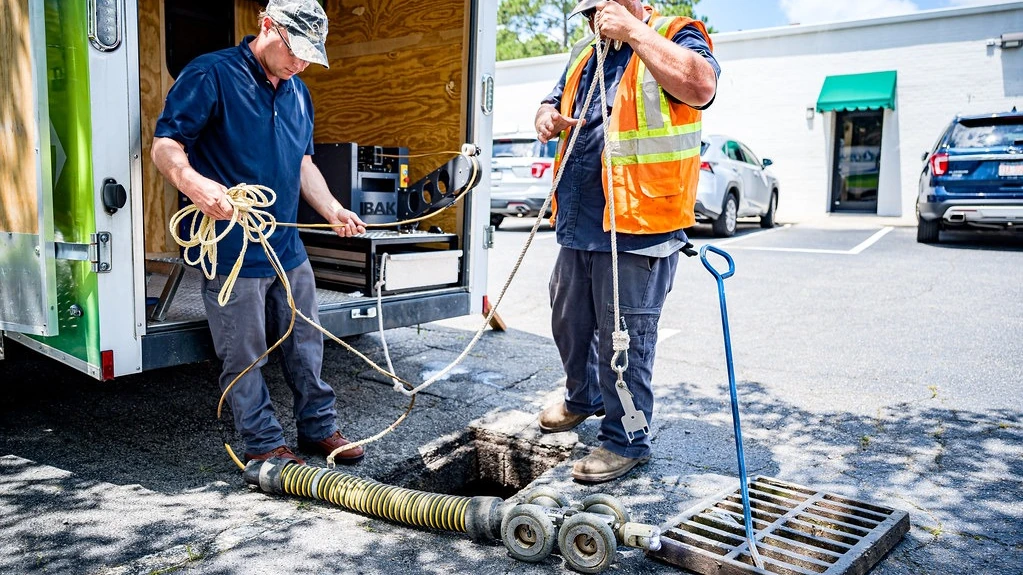 Drainage workers using pipe-inspection equipment during a connection review